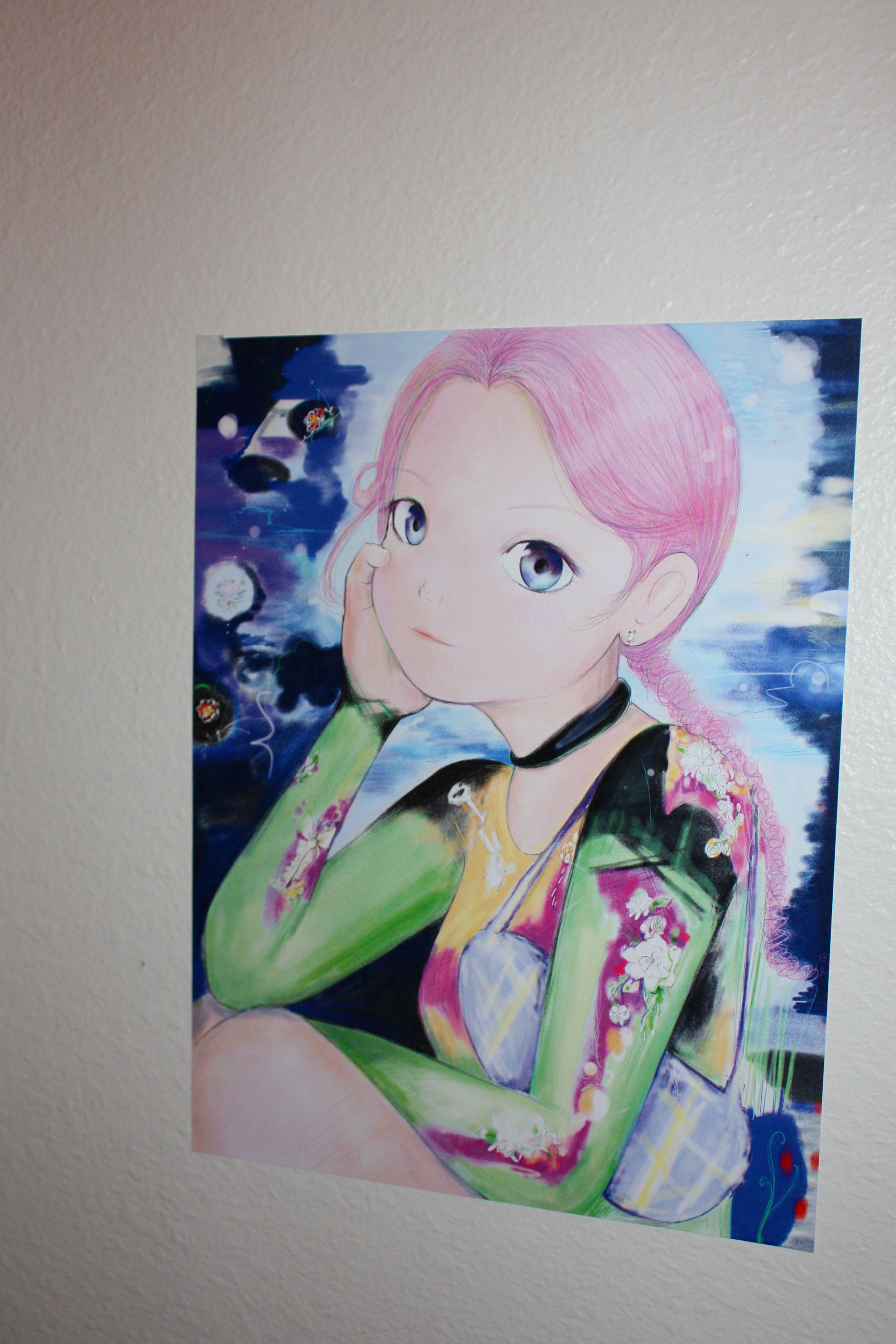 Detail of an anime girl with pink hair hung on a white wall